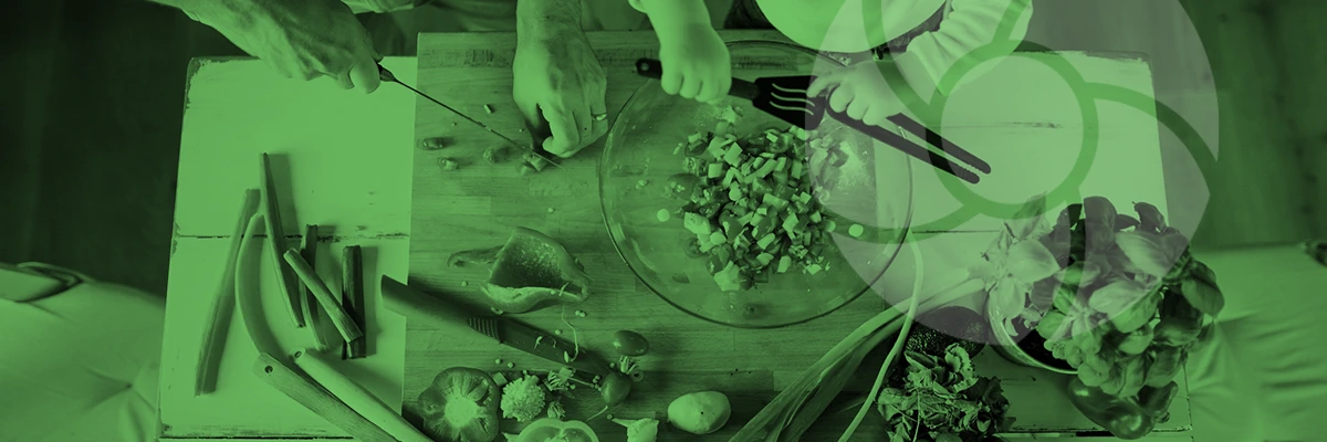 Chopping vegetables on a cutting board surrounded by various fresh ingredients and cooking utensils