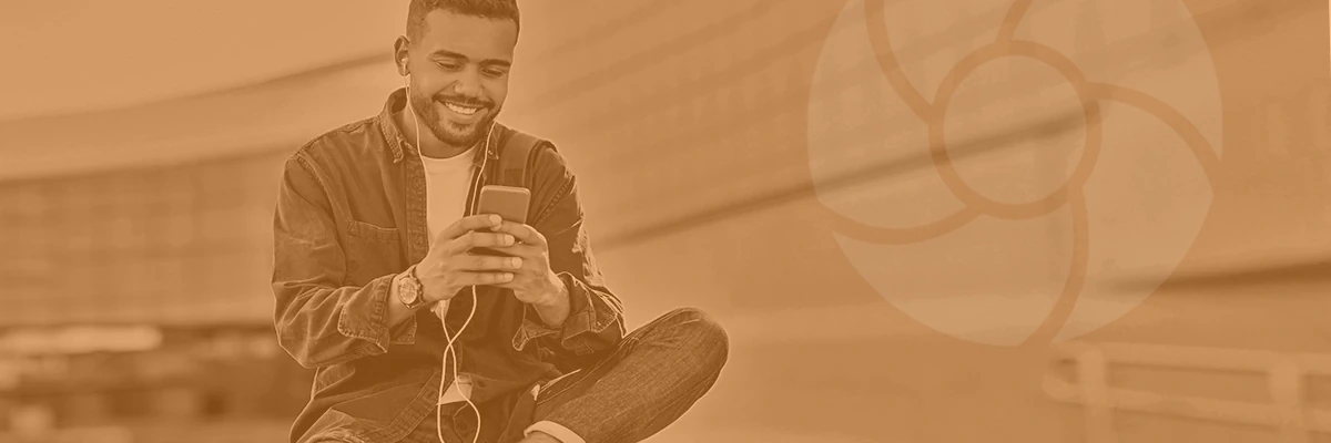 A young man sitting cross-legged, happily using his smartphone with earphones, in a sepia-toned image with the Foodsystems CDT program symbol